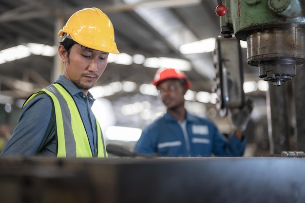 Aziatische arbeiders en Afrikaanse man fabriek werken bij staal zware machine engineering opleidingspersoneel