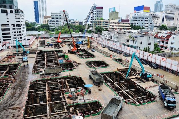 Aziatische arbeiders en Thaise arbeiders gebruiken machine en zware machines werken bouwer nieuwe structuur toren hoogbouw gebouw op steiger op bouwplaats in de hoofdstad in Bangkok Thailand