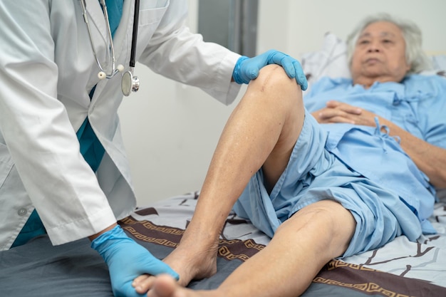 Aziatische arts injecteert hyaluronzuur-bloedplaatjesrijk plasma in de knie van oudere vrouw om pijnloos te lopen