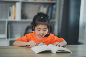 Aziatische baby jongen meisje houden vergrootglas over boek en lezen boek onderwijs mensen kinderen en school concept gelukkig lachend student meisje leren studeren onderwijs ontwikkelingsconcept