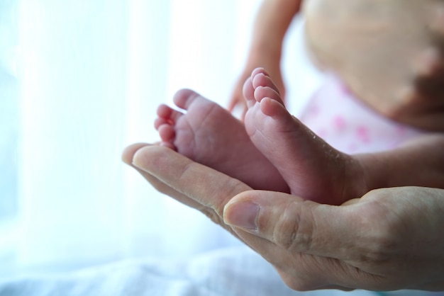 Aziatische baby meisje voeten in haar moeder hand.