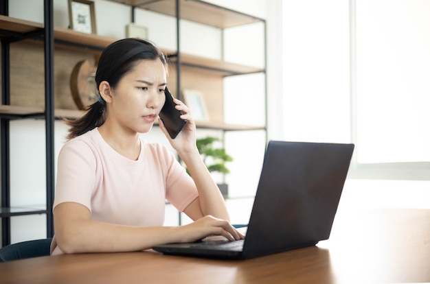 Aziatische bedrijfsvrouw met notitieboekje in het bureau