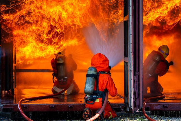 Aziatische brandweerman dienstdoende brandbestrijding aziatische brandweerman spuit water onder hoge druk brandweerman in brandblusapparatuur uniform spuitwater uit slang voor brandbestrijding