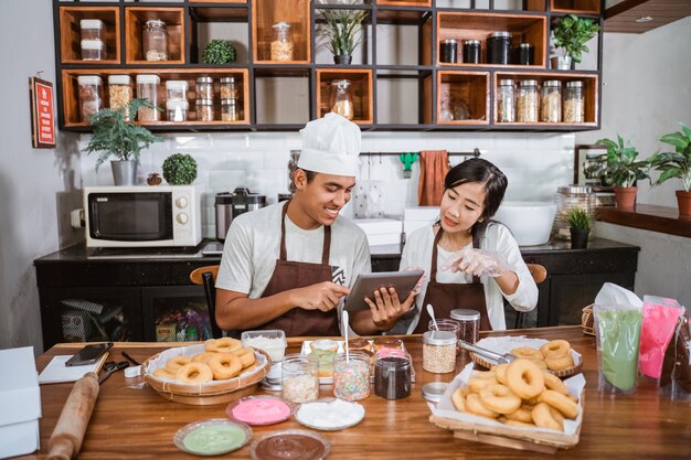 Aziatische chef-kok die zelfgemaakte donuts voorbereidt