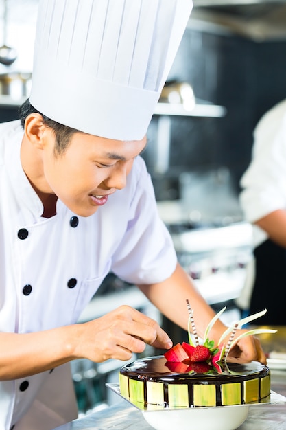 Aziatische chef-koks die in restaurant koken
