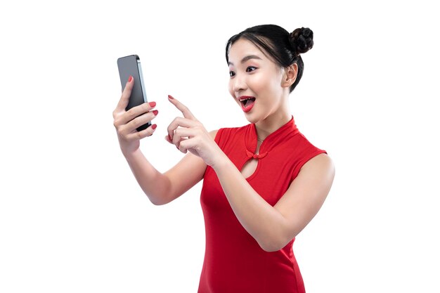 Aziatische Chinese vrouw in een cheongsamjurk die een mobiele telefoon gebruikt
