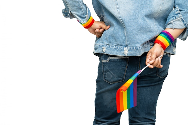 Aziatische dame die het blauwe jasje van jean dragen die de vlag van de regenboogkleur, symbool van lgbt-trotsmaand houden.