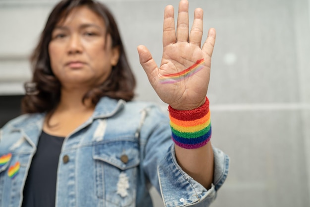 Aziatische dame die regenboogvlagpolsbandjes draagt, symbool van LGBT-trotsmaand viert jaarlijks in juni sociaal van homo-lesbische biseksuele transgender mensenrechten