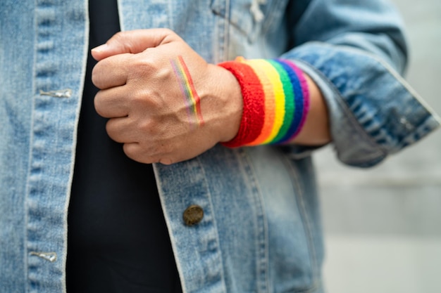 Aziatische dame die regenboogvlagpolsbandjes draagt, symbool van LGBT-trotsmaand viert jaarlijks in juni sociaal van homo-lesbische biseksuele transgender mensenrechten