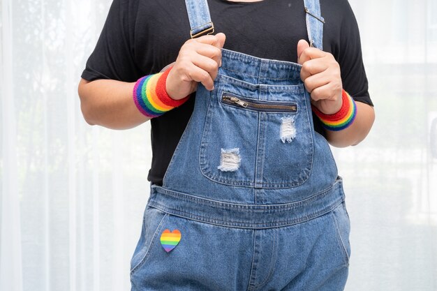 Aziatische dame die regenboogvlagpolsbandjes draagt, symbool van LGBT