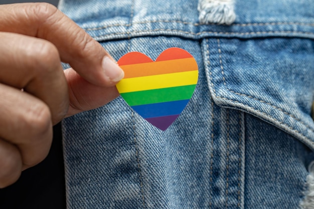 Foto aziatische dame met het hartsymbool van de regenboogkleur van de lgbt-trotsmaand