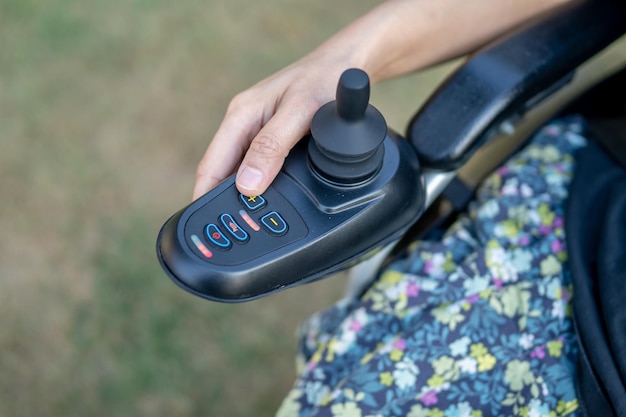 Aziatische dame vrouw patiënt op elektrische rolstoel met joystick op verpleegafdeling gezond sterk medisch concept