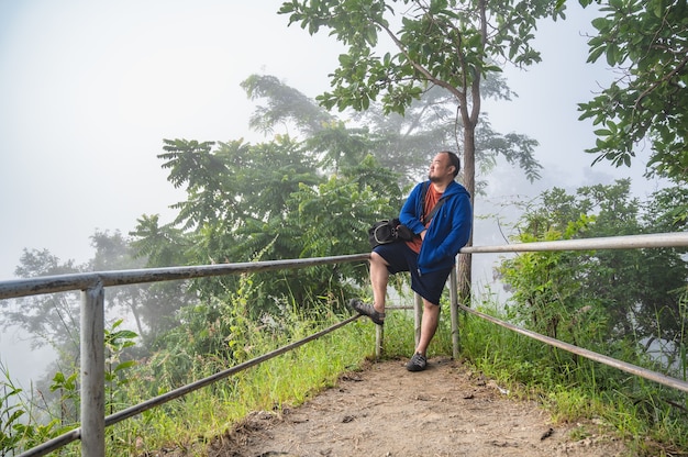 Aziatische dikke man op phu thok chiang khan in mistige dag. Chiang Khan is een oude stad en een zeer populaire bestemming voor Thaise toeristen