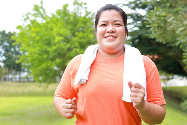 Aziatische dikke vrouw die glimlacht, gelukkig rennende buitenoefening om af te vallen Maak je lichaam gezond gezondheidszorg sportconcept