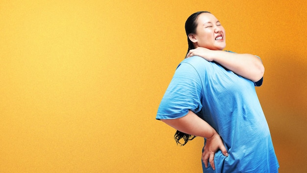 Aziatische dikke vrouw met overgewicht voelt rugpijn