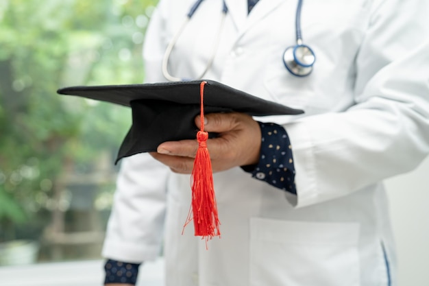 Foto aziatische dokter studie leren met afstuderen gap hoed in ziekenhuis afdeling slim helder genie onderwijs geneeskunde concept