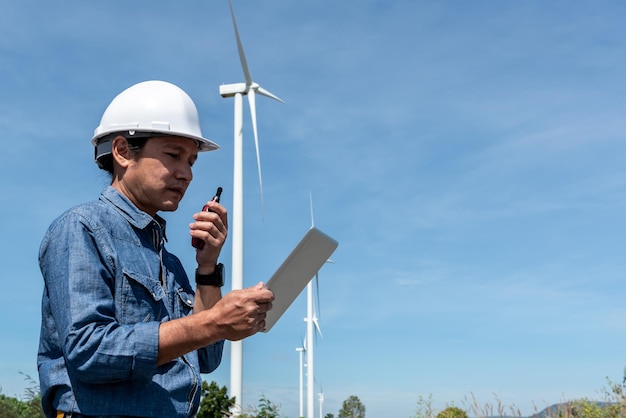 Aziatische elektrotechnisch ingenieur die een tablet vasthoudt en radiocommunicatie gebruikt