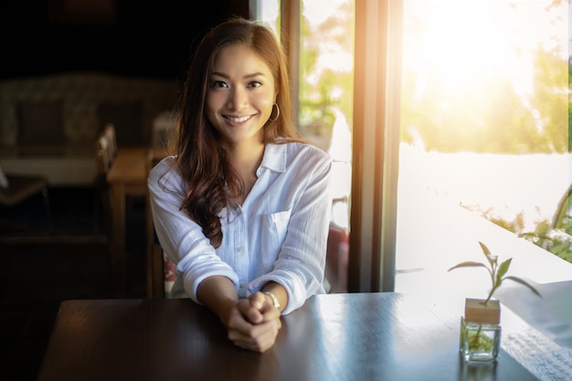 Aziatische en gelukkige vrouwen die glimlachen Ontspannen in een koffiewinkel