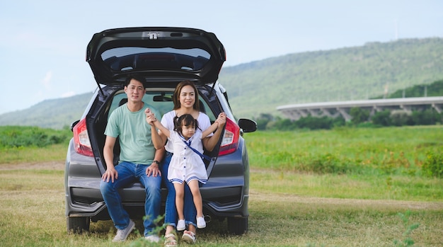 Aziatische familie. Gelukkig meisje met familie zitten in de auto. Autoverzekering concept