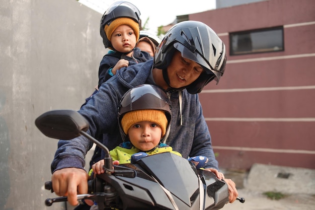 Aziatische familie rijdt op een motorscooter en reist samen met kinderen