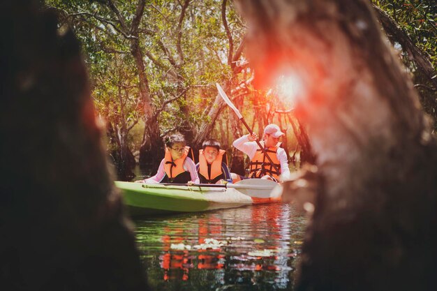 Aziatische familie zeilen zeekajak in mangrovebos