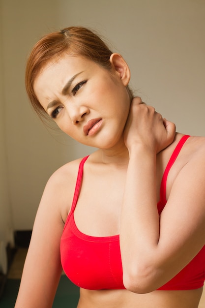 Foto aziatische fitness vrouw die lijdt aan nekpijn, sportblessure bij nekbot