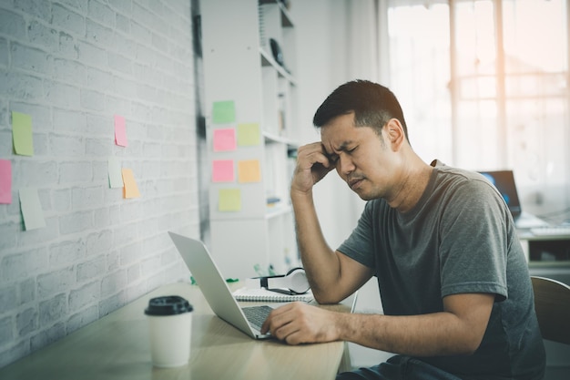 Aziatische freelance man met stressvolle depressie trieste tijd tijdens het werken videoconferentievergadering op laptop Depressie man trieste serios thuiswerken Werk overal concept