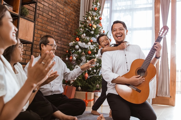 Aziatische gelukkige familie die Kerstmis samen thuis viert