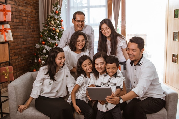 Aziatische gelukkige familie die Kerstmis samen thuis viert