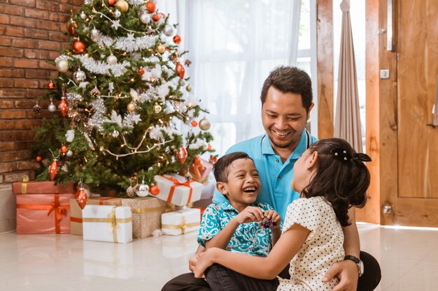 Aziatische gelukkige familie die Kerstmis samen thuis viert