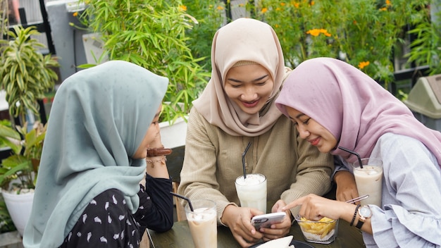 Aziatische groep hijab vrouw smilling in café met vriend