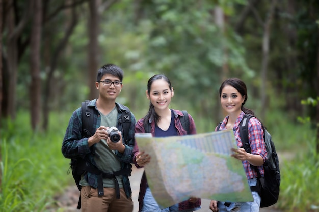 Aziatische Groep Wandeling met vriendenrugzakken die samen en kaart lopen lopen kijken