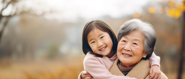 Aziatische grootmoeder en kleindochter knuffelen samen in het openluchtpark