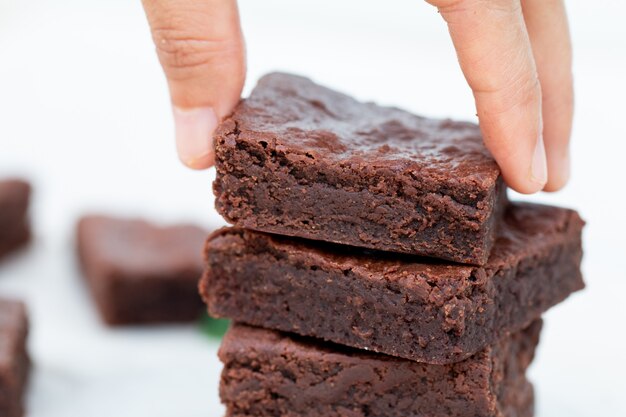 Aziatische hand plukken een chocolade brownie