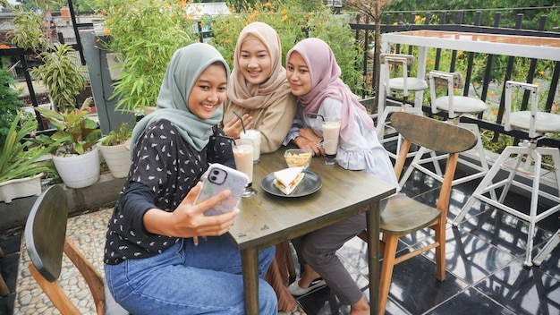 Aziatische hijab vrouw groep selfie in café met vriend