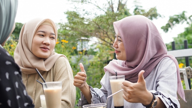 Aziatische hijab vrouw groep smilling in café met vriend