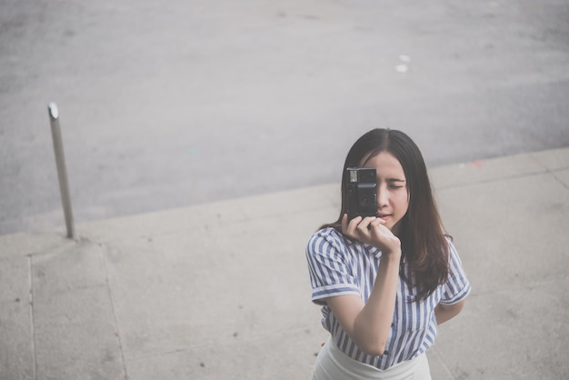 Aziatische hipsters meisje met zwarte camera actie nemen een foto vintage stijl