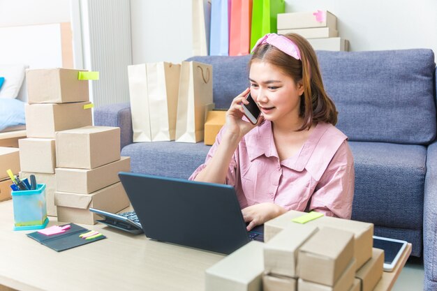 Aziatische huis online verkoper zakenvrouw in gesprek met haar klant op telefoon