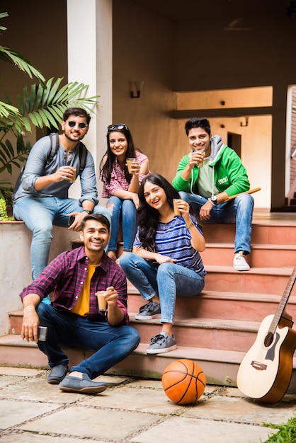 Aziatische indiase groep studenten die samen thee of koffie drinken in de pauze op de campus in de buitenlucht. een praatje maken