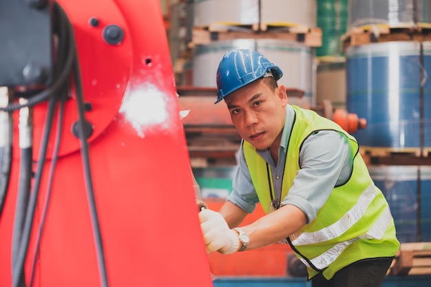 Aziatische ingenieur die controlemachine in fabriek werkt