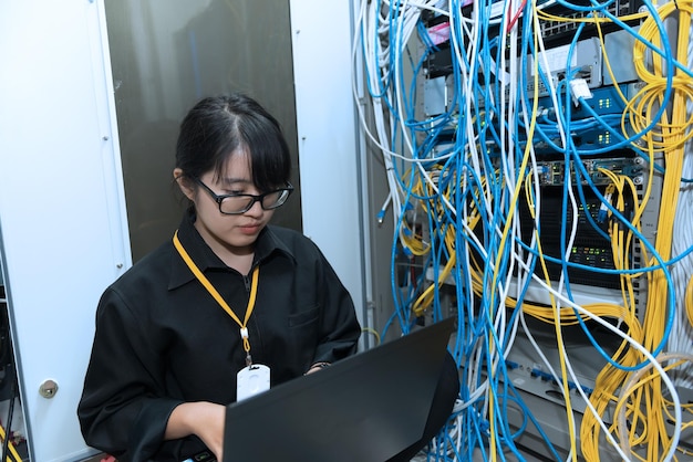 Aziatische ingenieur die in de serverruimte werktControleer de verbindingsproblemen van computernetwerkenThailand mensen