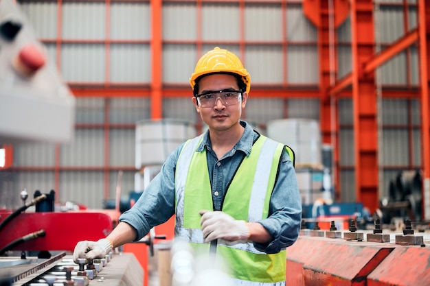 Aziatische ingenieur die in fabriek werkt met machineTechnische vaardigheid is industriële productie