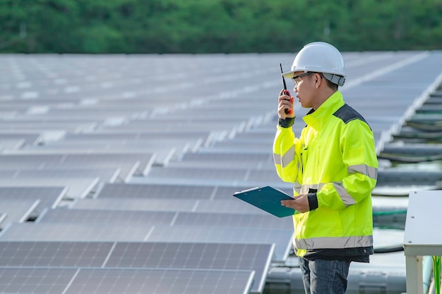 Aziatische ingenieur die werkt bij drijvende zonne-energiecentraleHernieuwbare energieTechnicus en investeerder zonnepanelen die de panelen controleren bij zonne-energie-installatie