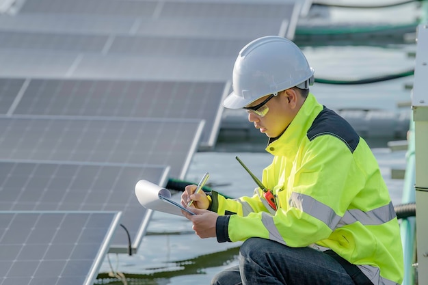 Aziatische ingenieur die werkt bij drijvende zonne-energiecentraleHernieuwbare energieTechnicus en investeerder zonnepanelen die de panelen controleren bij zonne-energie-installatie