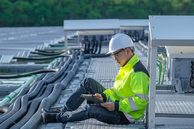 Aziatische ingenieur die werkt bij drijvende zonne-energiecentraleHernieuwbare energieTechnicus en investeerder zonnepanelen die de panelen controleren bij zonne-energie-installatie