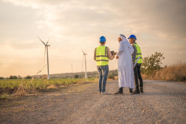 Aziatische ingenieur en Arabische zakenman die de hand schudden na het controleren en inspecteren van de bouw met zonsonderganghemel mensen die internationale zaken doen