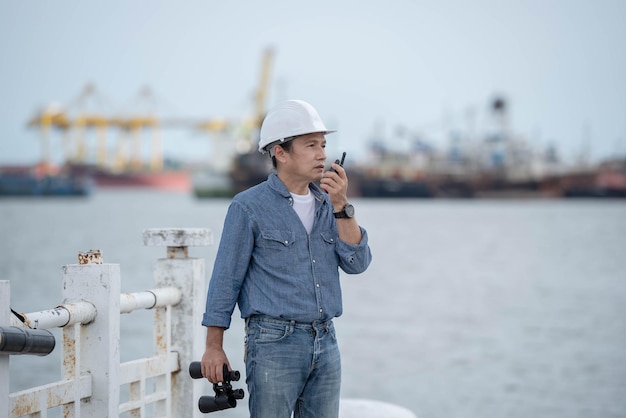 Aziatische ingenieur man met walkie talkie en verrekijker Vergelijk met echte locaties Voor constructie