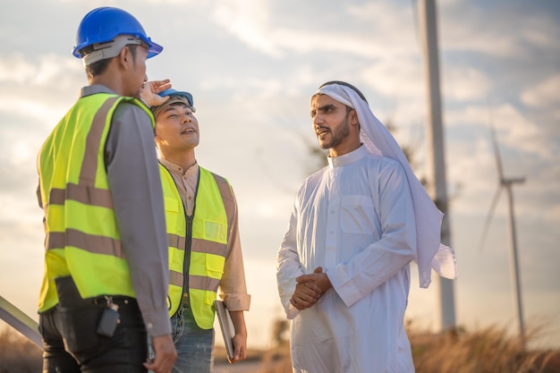 Aziatische ingenieurs en arabische zakenman controleren en inspecteren de bouw met avondrood