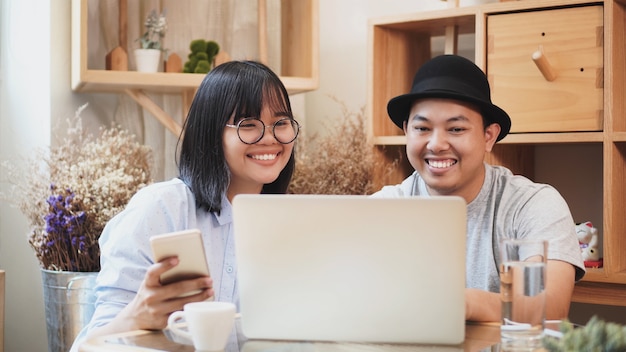 Aziatische jonge collega freelance in casual pak zitten om samen te werken met technologie laptop