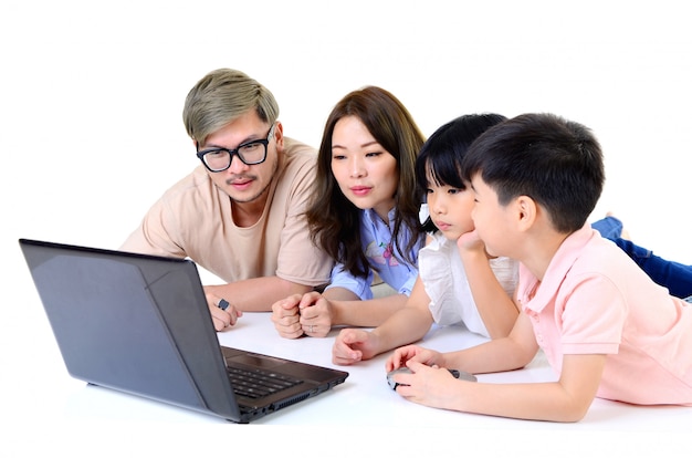 Aziatische jonge familie die laptop helemaal met behulp van